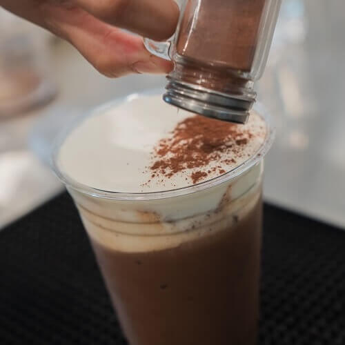 Milk being poured into an iced coffee drink